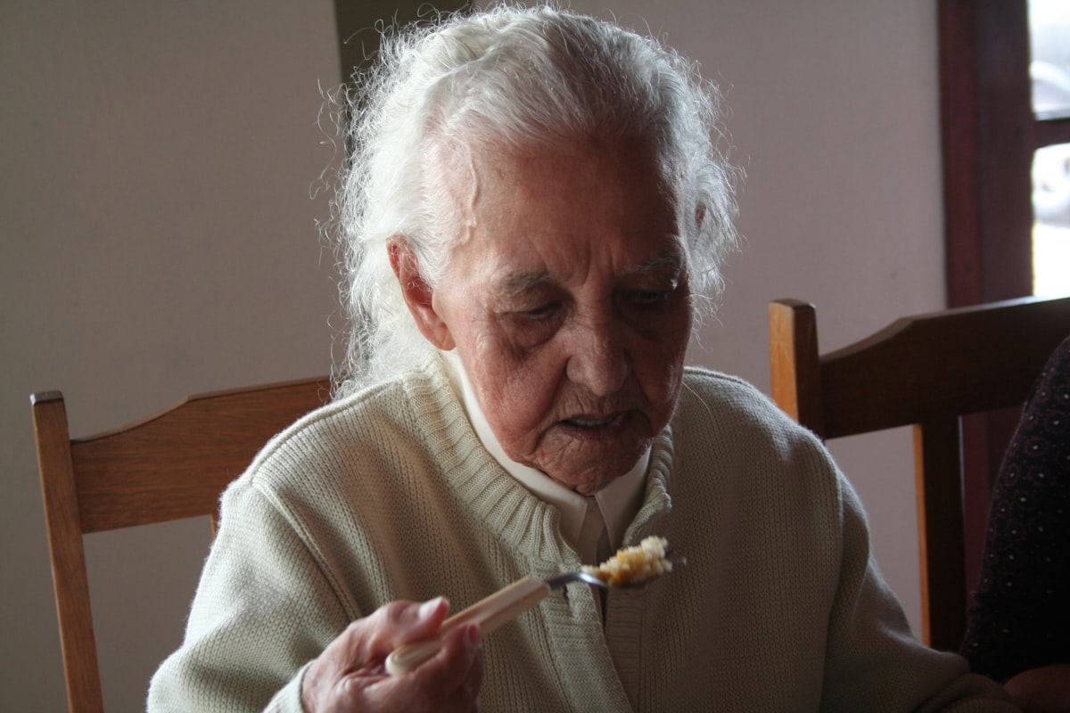 Seniorin bereitet gesunde Mahlzeit zu